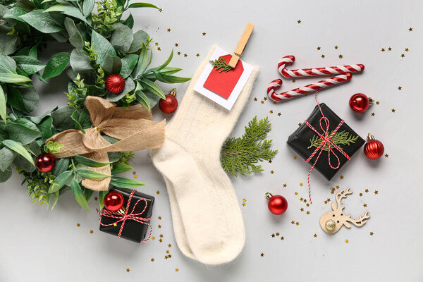 Beautiful composition with warm socks and Christmas decor on grey background