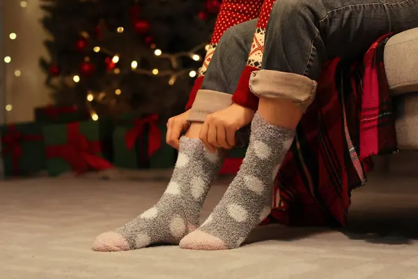 Woman in warm socks at home on Christmas eve
