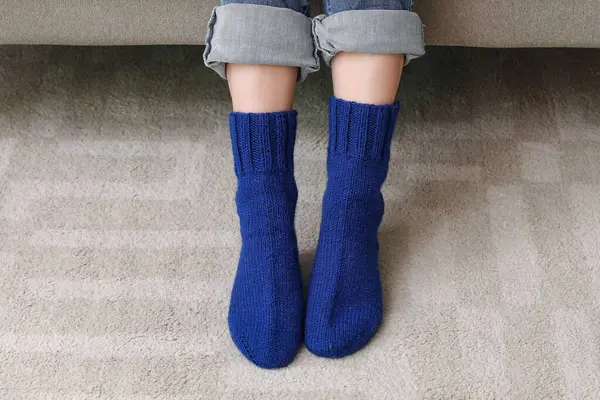 Woman in blue knitted socks at home