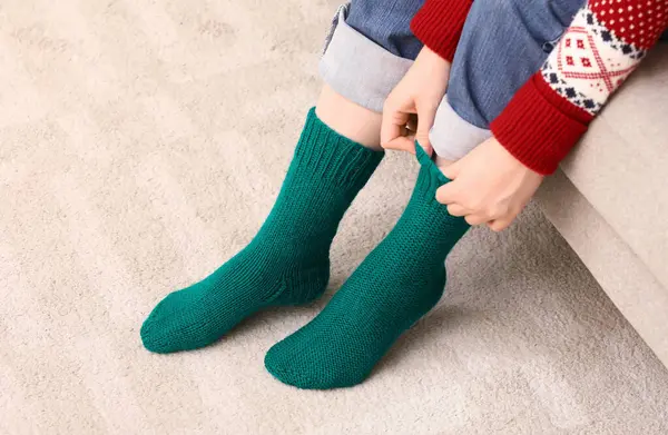 Woman in green knitted socks at home
