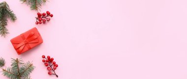 Noel hediyesi kutusu, böğürtlen ve köknar dalları pembe arka planda metin için yer var