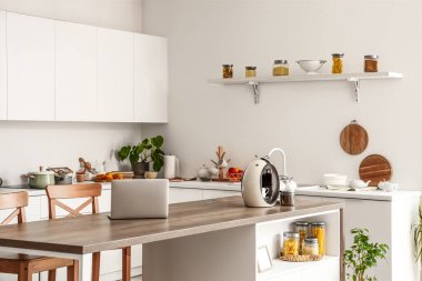 Modern kahve makinesi ve dizüstü bilgisayarlı hafif mutfağın içi.