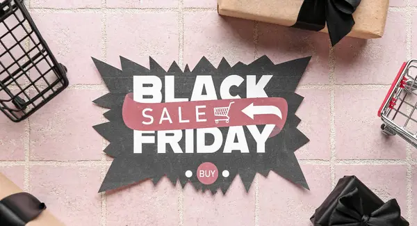 Card with text BLACK FRIDAY SALE, gifts and shopping carts on pink tile background