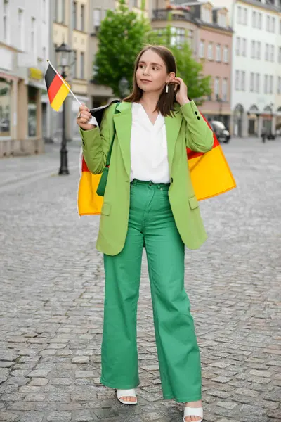 Young woman with flags of Germany on city street