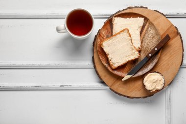 Beyaz arka planda tereyağlı tost ve bir fincan çay.