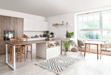 Ahşap masasında kahve makinesi olan modern mutfağın içi.