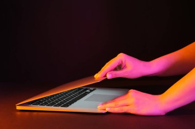 Siyah arka planda modern dizüstü bilgisayarla çalışan kadın