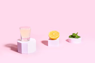 Lezzetli limoncello ve pembe arkaplanlı nane şekerli dekoratif podyumlar.