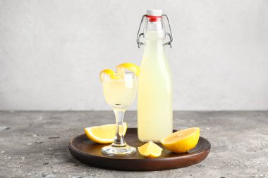 Ahşap tahta tahta ve bir bardak lezzetli limoncello gri masada.