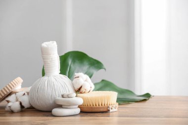 Spa aksesuarları ve ahşap masa üzerinde pamuk çiçekleri olan kompozisyon