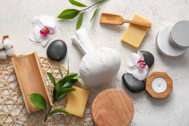 Kaplıca malzemeleri ve açık arkaplanda orkide çiçekleri olan kompozisyon