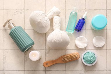 Hafif fayans zemininde kozmetik ürünleri ve spa aksesuarlarıyla kompozisyon