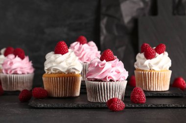 Siyah arka planda lezzetli ahududulu kekler.