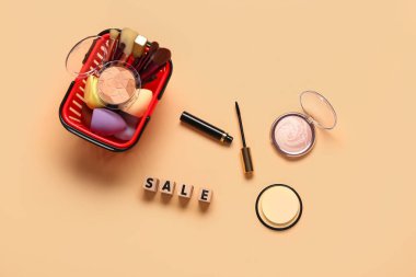 Makyaj malzemeli alışveriş sepeti ve bej arka planda metin satışı