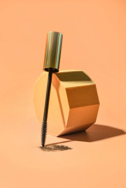 Siyah rimel fırçası ve turuncu arkaplan örneği ile dekoratif podyum