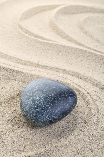 Zen meditation stone in sand with wave pattern background, zen concept