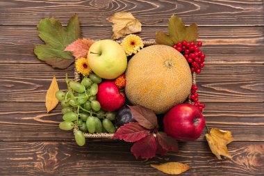Tahta arka planda farklı taze meyvelerle dolu sepet.