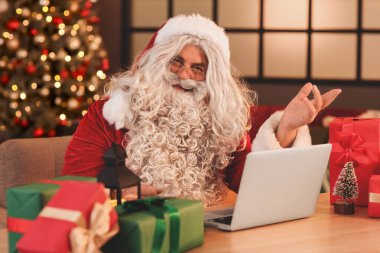 Noel arifesinde evde dizüstü bilgisayarlı Noel Baba