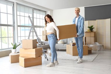 Taşındığı gün odada karton kutu taşıyan genç bir çift.