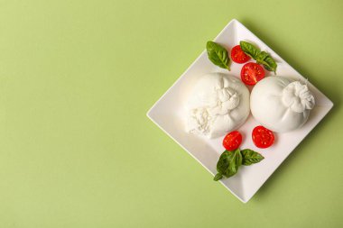 Yeşil arka planda lezzetli Burrata peyniri tabağı