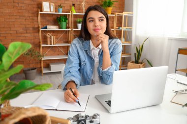 Ofiste deftere yazı yazan genç bir kadın.