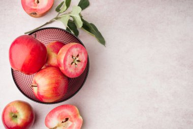 Tatlı pembe elmalı kase ve beyaz arka planda yapraklar