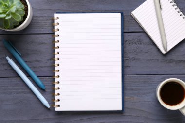 Kalemli defterler ve mavi ahşap arka planda bir fincan lezzetli kahve.