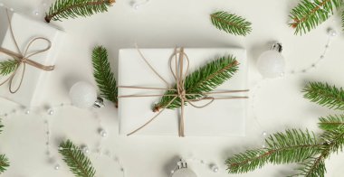 Noel hediyesi, köknar dalları ve beyaz arka planda süslemeler, üst görünüm