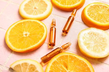 C vitamini ve pembe fayanslı farklı turunçgil dilimli ampuller.