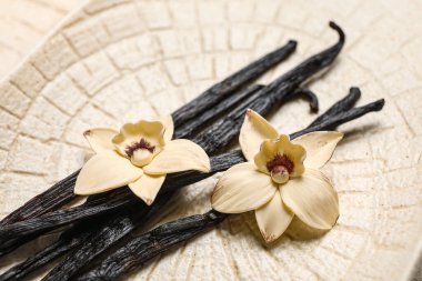 Aromatik vanilyalı tabaklar ve çiçekler, yakın plan.