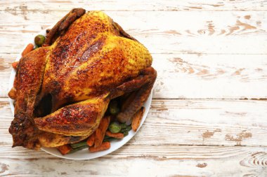 Beyaz ahşap arka planda, Şükran Günü için lezzetli hindili ve farklı sebzeli tabak.