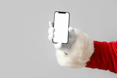 Noel Baba 'nın elinde cep telefonu ve gri arka planda boş ekran var.