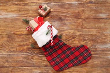 Noel çorabı hediye kutuları ve tahta arka planda şeker kamışları.