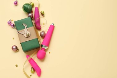 Bej arka planda hediye kutusu ve Noel dekoru olan vibratörler