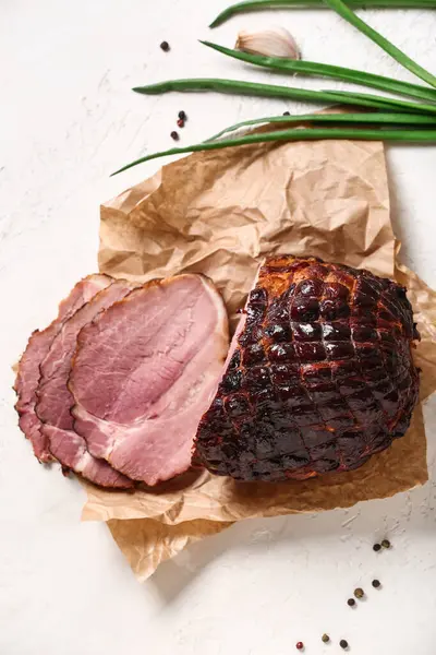Tasty smoked ham on light background