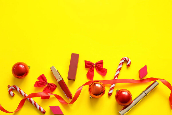 Макияж и красные рождественские украшения на желтом фоне