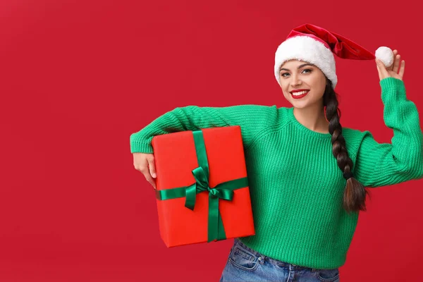 Mooie Jonge Vrouw Santa Hoed Met Kerstcadeau Rode Achtergrond — Stockfoto