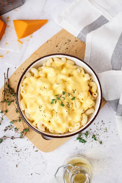 Hafif arka planda Çedar peynirli bir kase lezzetli İtalyan makarnası.