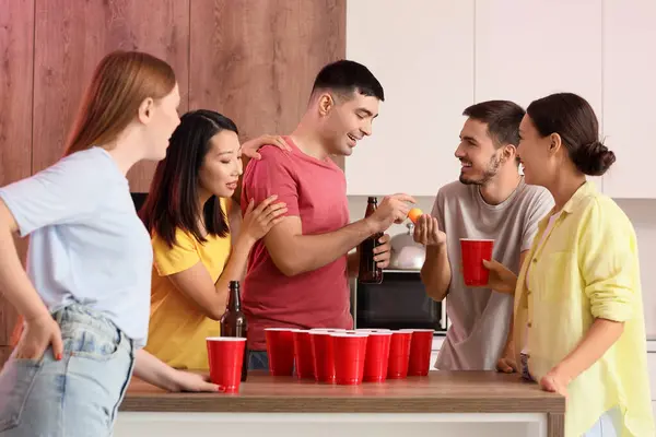 Bir grup genç arkadaş partide bira pong oynuyorlar.