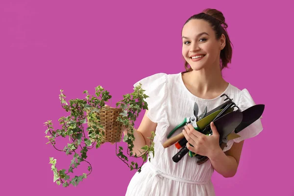 有园艺工具和紫色背景植物的年轻妇女 — 图库照片