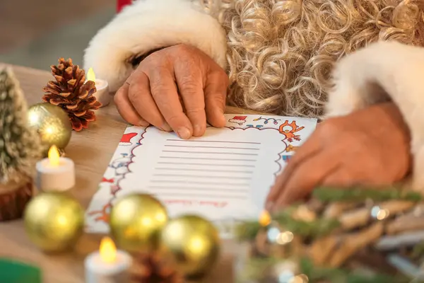 Santa Claus reading letter at table, closeup