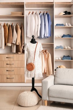 Şık giysileri, mankeni ve kanepesi olan bir butiğin içi.