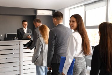 İş adamları resepsiyonda sıra bekliyor.