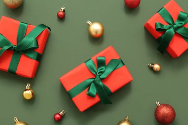 Yeşil arka planda hediye kutuları ve Noel topları