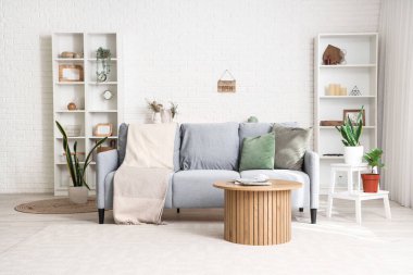 Kanepesi, masası ve çiçekleri olan bir oturma odası.