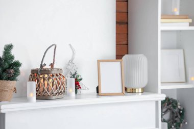 Parlak fener, Noel süsü ve şömine rafında boş çerçeve, şenlikli oturma odasında, yakın çekim.