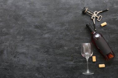 Siyah arka planda tirbuşon ve bir şişe nefis şarap.