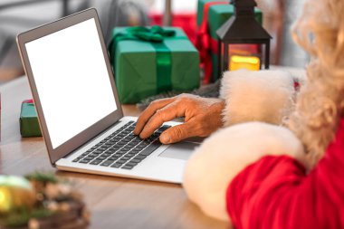 Noel Baba Noel arifesinde dizüstü bilgisayar kullanıyor, yakın plan.