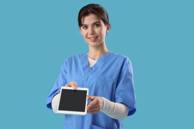 Mavi arka planda tablet bilgisayarı olan kadın stajyer.