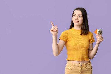 Prezervatifli genç ve güzel bir kadın mor arka plandaki bir şeyi işaret ediyor. AID farkındalık kavramı